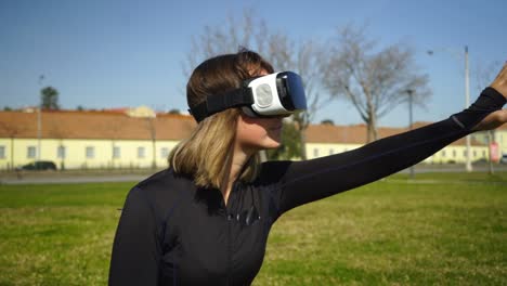 Sportliches-Mädchen-Im-Virtual-Reality-Headset,-Das-Auf-Gras-Sitzt
